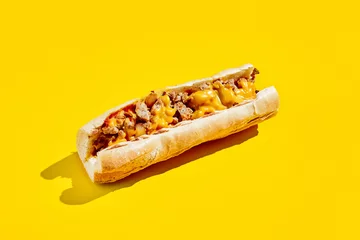Tuinposter Chiken cheesesteak in minimal style. American fast food in yellow background with shadow. Philly steak sandwich trendy concept. Junk food in colour background. © Ryzhkov