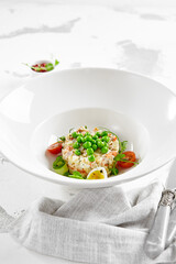 Original russian potato salad with green peas and mayonnaise. Russian christmas menu. Olivier salad with boiled potatoes, carrots, eggs, peas and meat with mayo dressing.  Traditional New year dish.