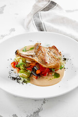 Roasted pork steak with vegetables garnish and sauce. Bone-in ribeye pork chops. Main course of pork in rustic style.