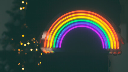 Girl holds neon led rainbow in hands in the night