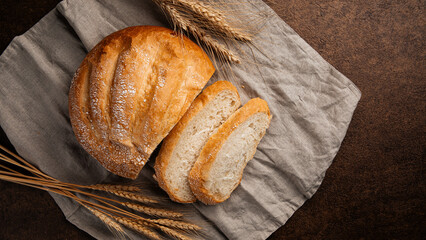 Freshly baked sliced loaf of creamy bread on napkin 