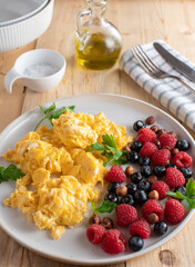 Ketogenic breakfast plate with scrambled eggs, fresh berries and hazelnuts