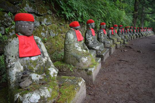 Statues of Ksitigarbha bodhisattva (Jizo) with red caps and bibs in Nikko, Japan
