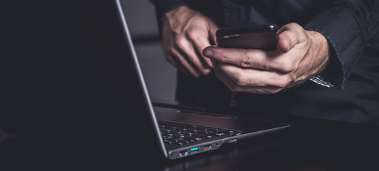 Businessman using a smartphone and notebook in a moddy office