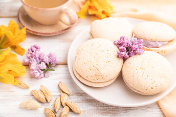 Meringues cakes with cup of coffee on a white wooden background. Side view, selective focus.