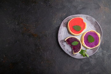 Sweet tartlets with jelly and milk cream on a black concrete background. top view, copy space.