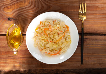Eating Sauerkraut with vegetable oil. National european dish Pickled cabbage carrot Homemade fermented by lactic acid bacteria Lactobacillus brine. Healthy local food sour flavor Vitamin C Winter menu