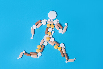 Abstract man made of medical pills on blue background. Nutritional supplements and vitamins concept