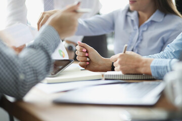 Coworkers discussing working moments and checking financial report in conference room