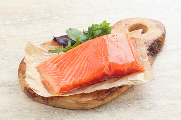 Raw salmon fillet over board