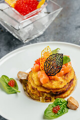 Potato pancakes with red caviar, red fish and mushroom sauce. banner, menu, recipe place for text, top view