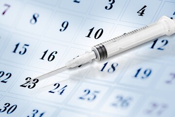 Covid vaccine dose concept. Syringes are seen on calendar as a concept for the covid-19 vaccine dose,