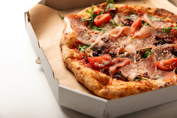 Banner
close-up of Delicious pizza in a box on a white background. Top view of hot pizza. With copy space for text.