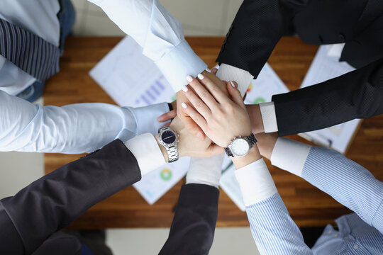 Colleagues performing gesture in order to prepare for important profitable project