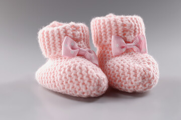 Pair of knitted pink baby booties with cute bow on it