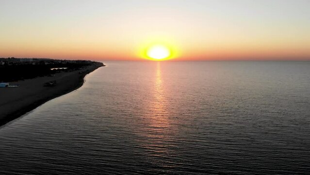 Drone shot Sunrise on the Black Sea in Zatoka. Sunrise Odessa. People walk by the sea at sunrise. The first rays of the sun on the sea in Odessa. Drone shot of Zatoka resort at sunrise