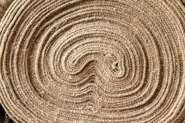 Fototapeta na wymiar Linen fabric rolled up. Texture of old handmade linen fabric. 