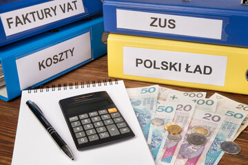New tax law in Poland called Polski Ład, files, calculator and Polish currency on a desk