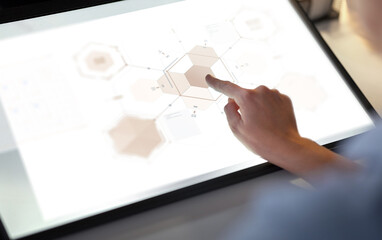 technology and people concept - hands on led light tablet or touch screen with virtual projection at night office