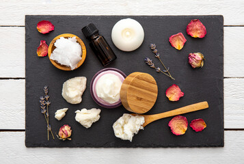 Making bodywhip also known as body butter, skin care moisturizer cream. Ingredients on wood background: shea butter,solid coconut oil, essential oils. Ready made body foam butter inside jar.