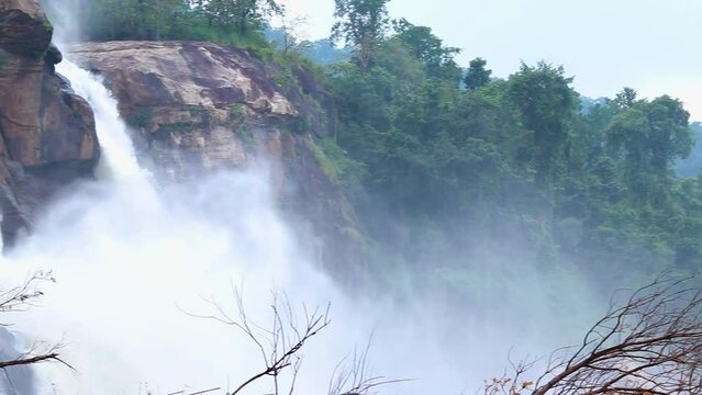 waterfall misty flowing water dropping from mountain top at morning