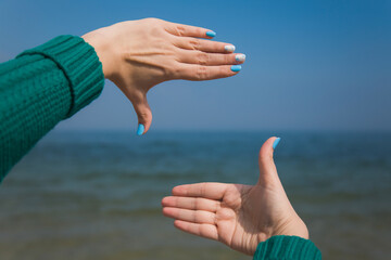 Close-up point of view shot photography of female caucasian hands isolated on blue sky background....