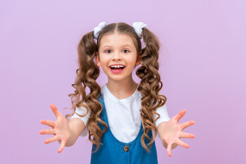 The joyful baby stretched out her hands and asked for something. Please give me a thing. A child with long curly hair on an isolated background.
