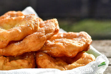 Traditional home made deep fried  patties  covered with sugar  оn rustic backgroud.Mekitsa or Mekica,  on wooden  rustic  background. Made of kneaded dough that is deep fried  .Carnival tortelli stuff