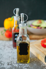 Plate of vegetable and avocado salad, olive oil and wine vinegar in bottles. Healthy food. Vegetarian. Tomatoes and green salad. Organic products. Eco. Home.