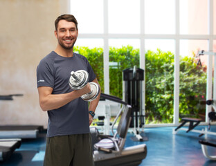 fitness, sport and bodybuilding concept - happy smiling man exercising with dumbbells over gym background
