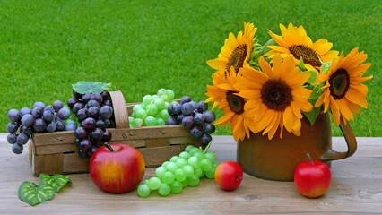 Naklejka na ściany i meble Tisch im Garten mit Sonnenblumen, Äpfeln und Weintrauben.