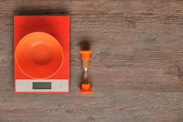 Creative kitchen utensils, nice combination of wood color and bright orange color. Scales, sandboxes, bowl. The concept of healthy eating, time does not wait.