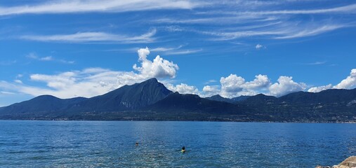 Torri del Benaco, Italy, Lake Garda, August 2021 View of the lake and the mountain formation from the east side to the west side of the lake in beautiful weather with blue sky