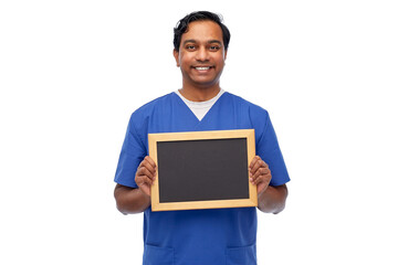 healthcare, profession and medicine concept - happy smiling indian male doctor or nurse in blue uniform with chalkboard over white background