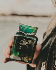 bottle of smoke, colorful jar in hands