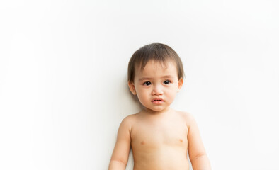 Portrait of baby boy standing crying on white isolated background. Cute little son child is crying....