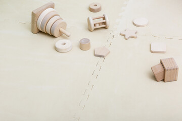 Wooden toys on a beige background. Montessori materials and toys. Eco-friendly plastic-free toys for children. Top view, copy space.