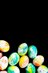 Top view multicolored eggs on a black isolated background. Happy Easter card. Dyed Easter eggs. Copy space for your text. Flat lay style. Top view. 