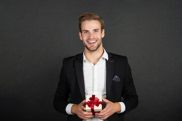 cheerful elegant guy in businesslike suit hold valentines day gift, be my valentine