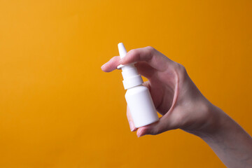 female hand holding nose spray
