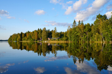 Wunderschöner Blick auf Stukas Ferienhäuser vom See aus in Schweden mit Spiegelungen im Wasser...