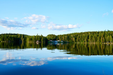 Wunderschöner Blick auf Stukas Ferienhäuser vom See aus in Schweden mit Spiegelungen im Wasser vom Boot aus Im Schwedenurlaub