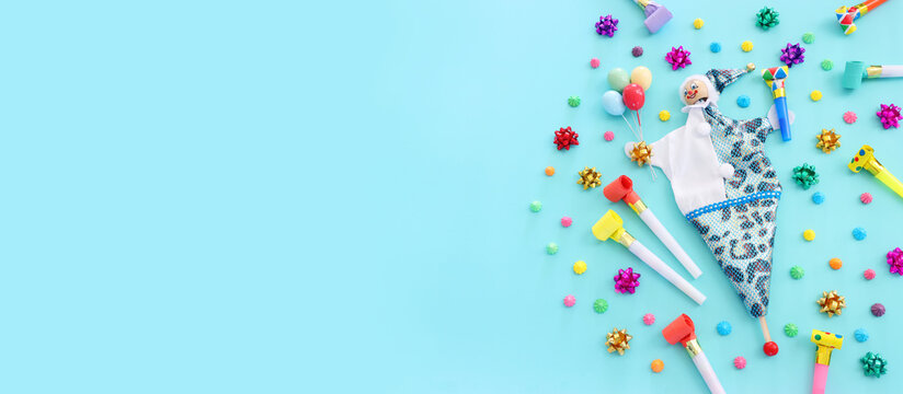 Holidays image of party colorful objects and cute clown over blue background. view from above. banner