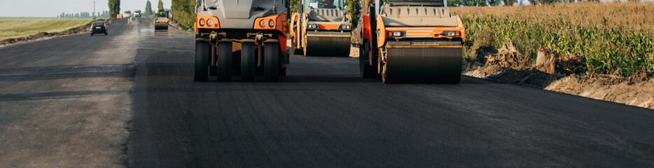 Vibratory asphalt roller compactor compacting new asphalt pavement. Road service repairs the highway