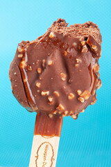 
Chocolate ice cream with almonds. On a stick. On a blue background