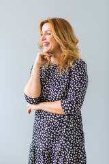 Beautiful mature woman in a fashionable dress posing in front of the camera