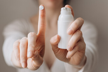 Cream skin care hands. Close-up woman holding cream for hands. Woman applying hand cream. Girl holding tube with skin care product.View from front.