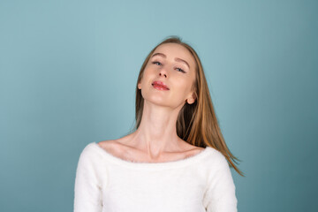 Close beauty portrait of a woman with perfect skin and natural makeup,white soft sweater, on a blue background