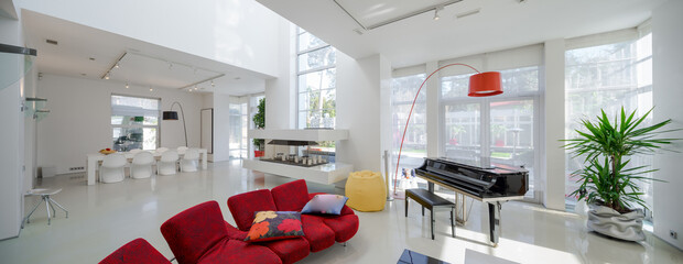 Modern interior. Luxury private house. Living room. Red sofa, piano