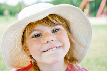 Portrait of preschool girl with straw hat. Cute happy toddler child looking at the camera and...